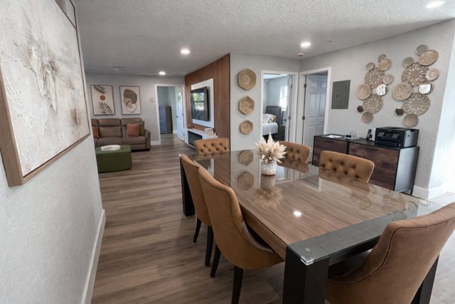 Dining table with upholstered chairs in an open living and dining area at a Serenity Living home
