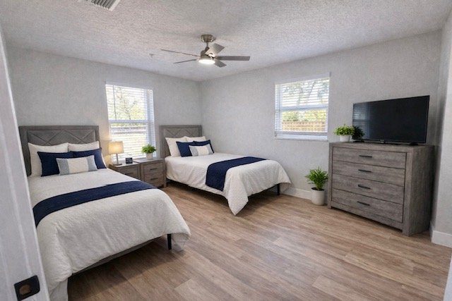 Semi-private bedroom at a Serenity Living home with two made beds, a dresser and a TV
