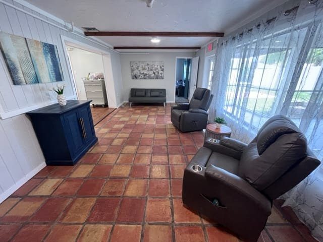Bright tiled sitting room with recliners and large windows at a Serenity Living home